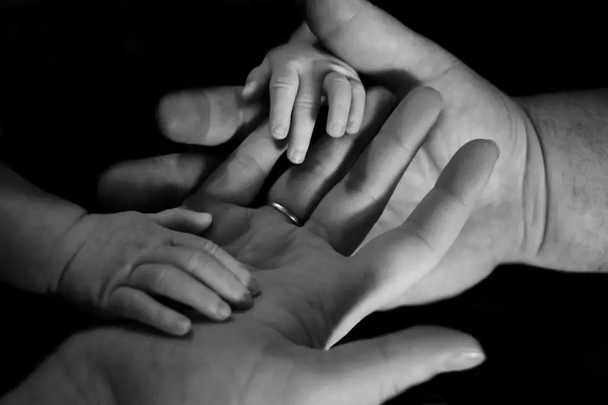 Kinderhände, die in den Händen eines Erwachsenen liegen