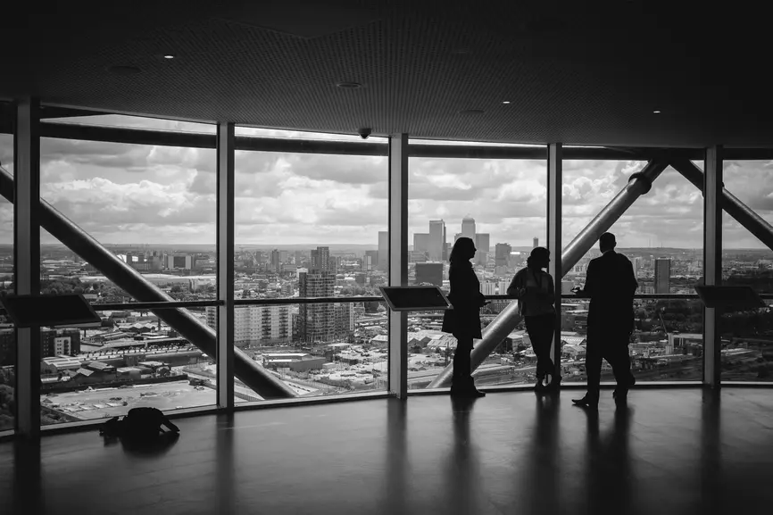 Menschen in Bürogebäude mit Aussicht auf eine Stadt