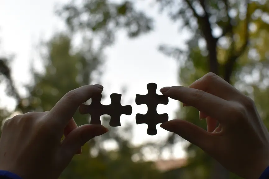 Zwei Puzzlestücke, die nebeneinander gehalten werden